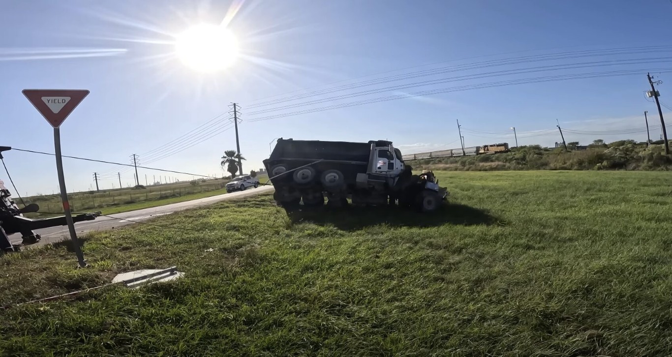 Heavy recovery truck pulling a dump truck from a roadside ditch after an accident
