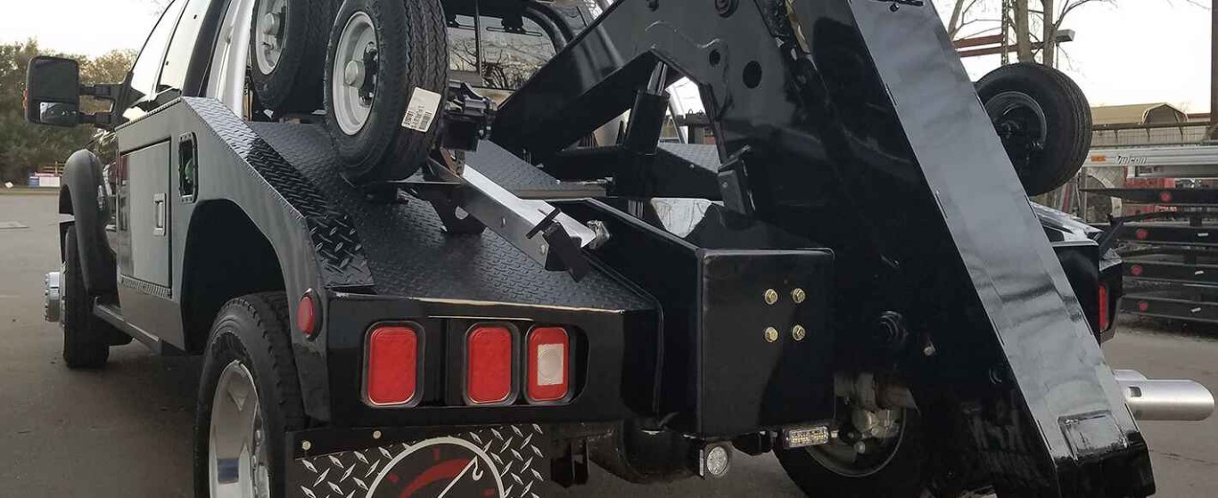 Heavy duty black tow truck with wheel lift equipment for commercial and large vehicle towing